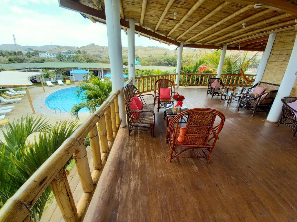 a porch with chairs and a table and a pool at Mancora y Sol in Máncora