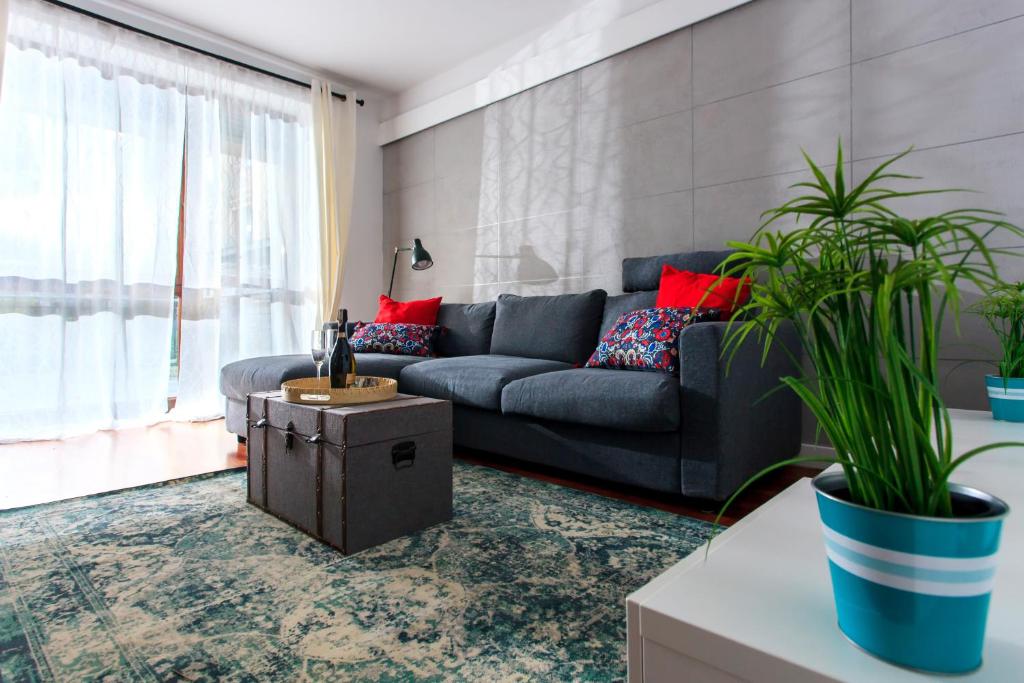 a living room with a couch and two potted plants at Comfy Apartment Dobra 54 in Warsaw