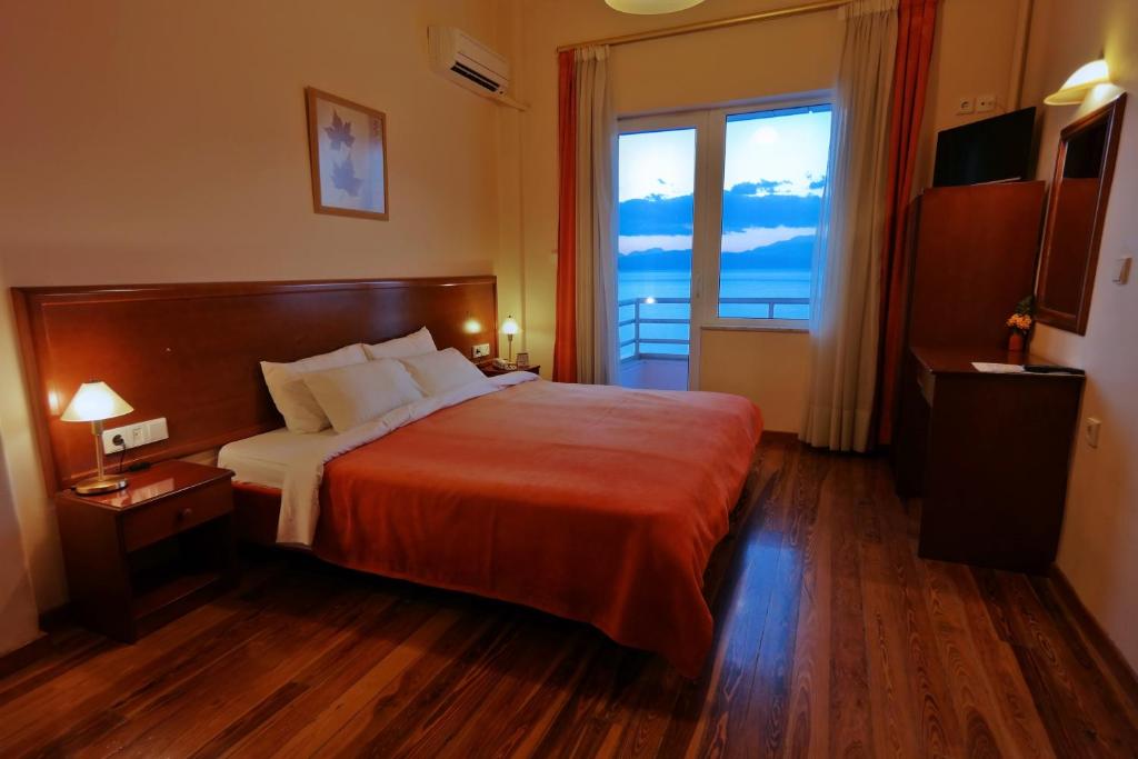 a hotel room with a bed and a large window at Hotel Excelsior in Loutraki