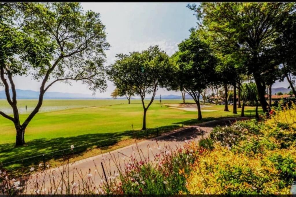 pole golfowe z drzewami i polną drogą w obiekcie Pecanwood villa on Hartbeespoort Dam w mieście Hartbeespoort
