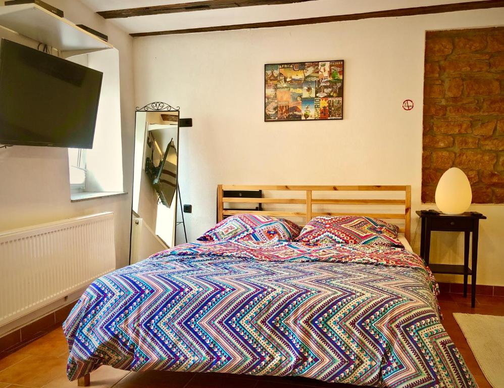 a bed with a colorful comforter in a bedroom at C&A Apartments in Kaiserslautern