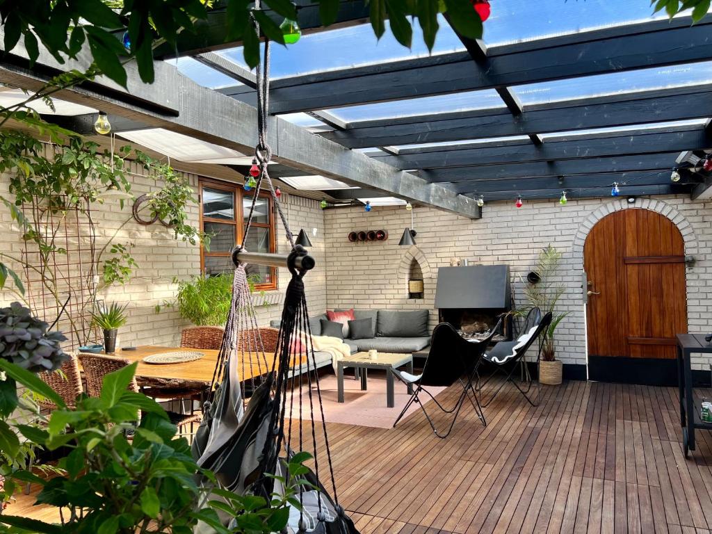 eine Terrasse mit blauer Decke sowie einem Tisch und Stühlen in der Unterkunft Rosengren Residence, Fireplace & barbecue in Billund