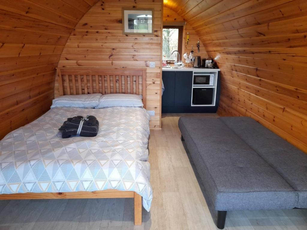a bedroom with a bed in a log cabin at Glamping Pod Thady Killynick County Fermanagh in Killyhevlin
