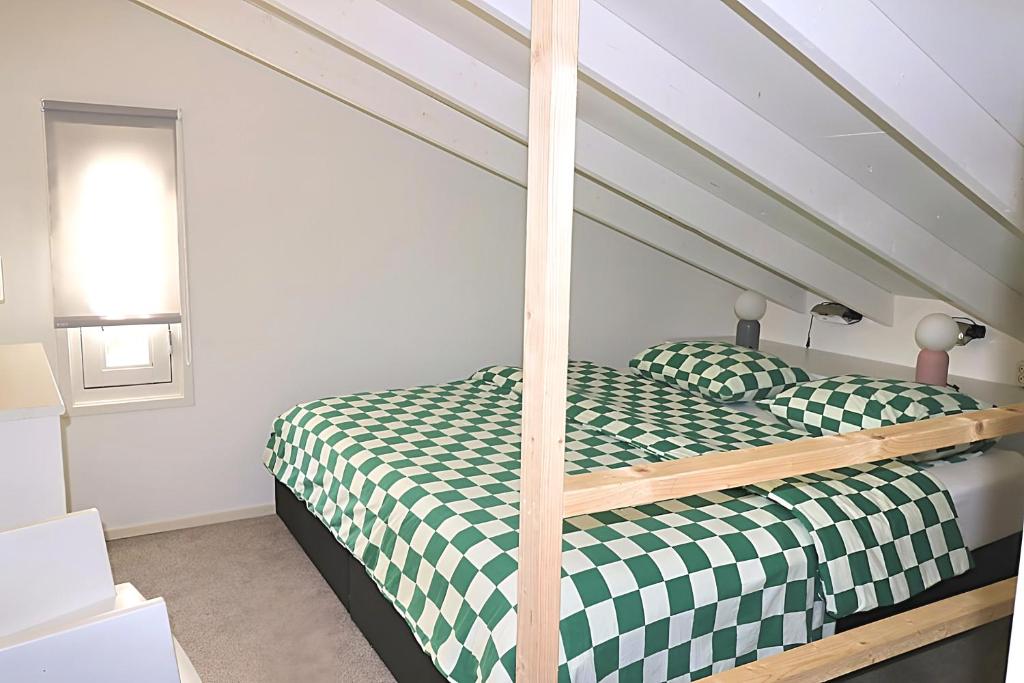 una camera con un letto e un piumone verde e bianco di B&B NR5 a Herbaijum