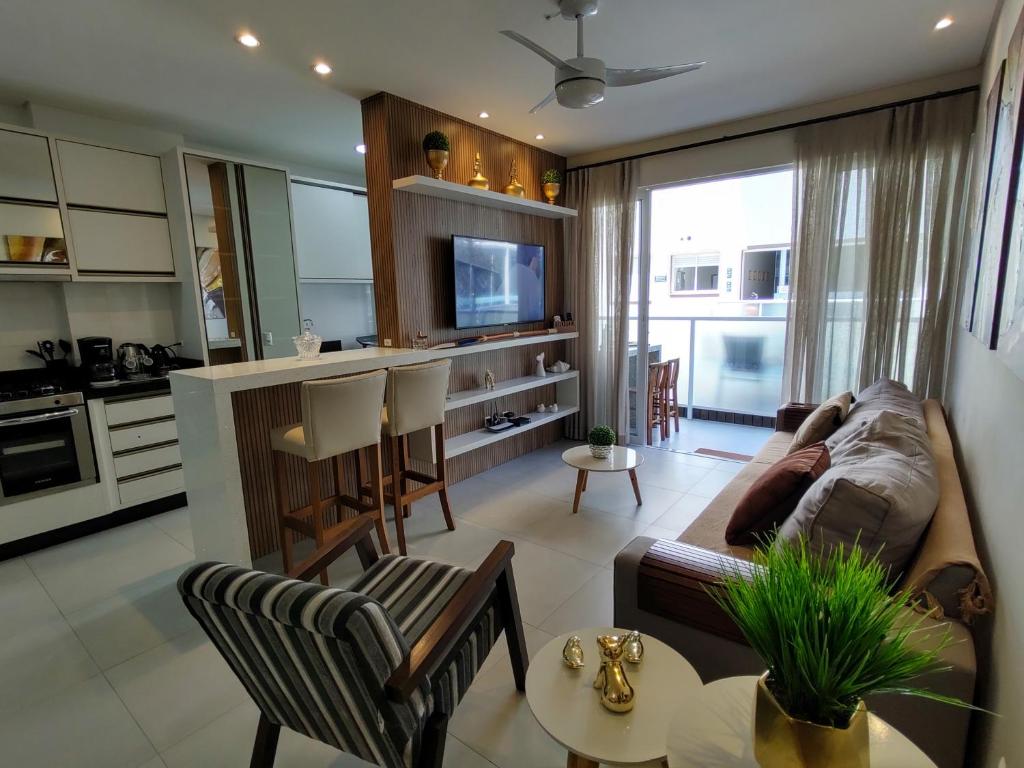 ein Wohnzimmer mit einem Sofa und einem Tisch in der Unterkunft Mariscal, 03 dormitórios, 80m do mar, com piscina in Bombinhas