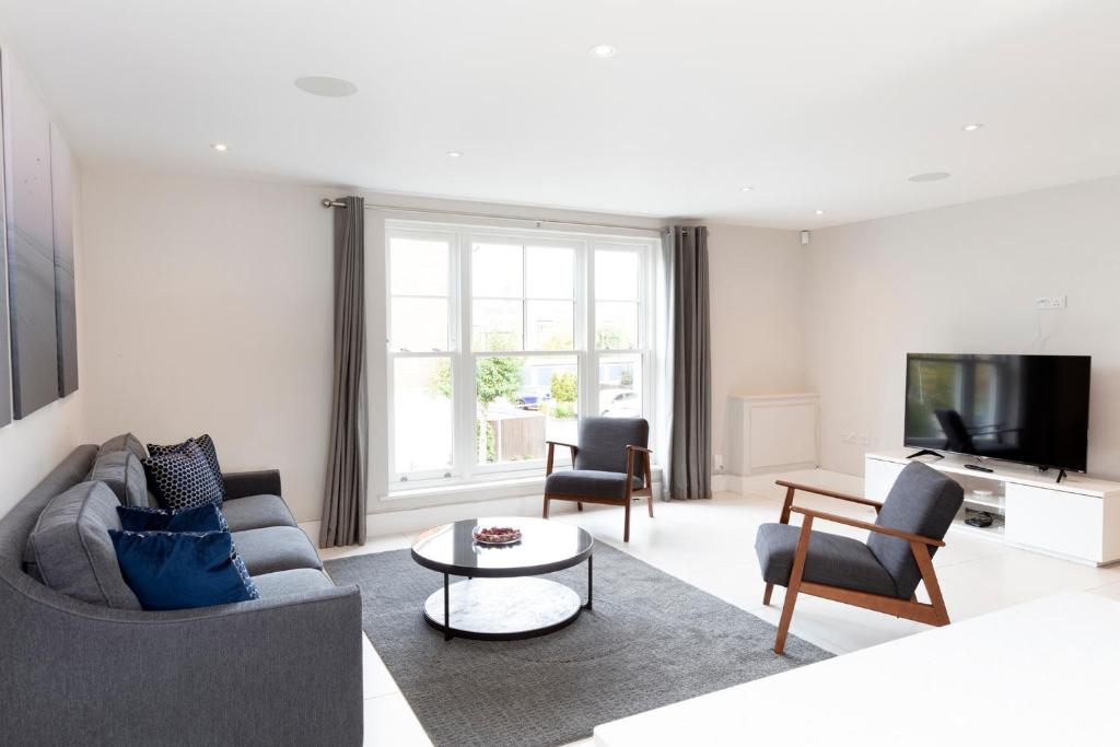 a living room with a couch and chairs and a tv at Fabulous Central Windsor Town House With Parking in Windsor