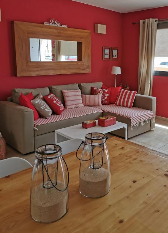 a living room with a couch and red walls at My place in Cotillo 6 in El Cotillo