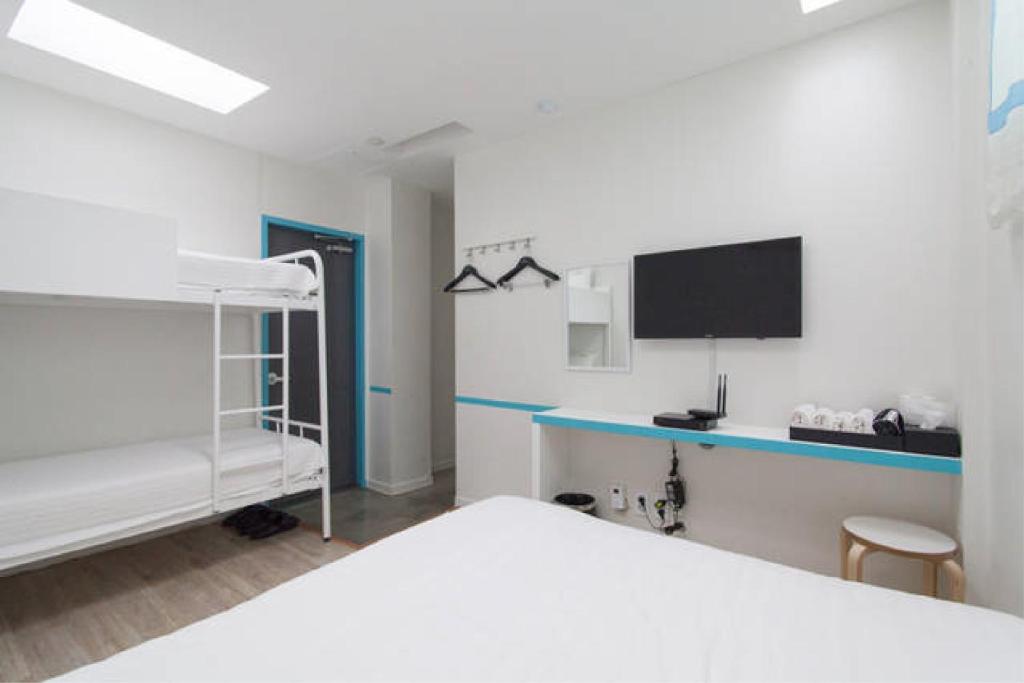 um quarto com um beliche e uma televisão em Starhostel Dongdaemun Suite em Seul