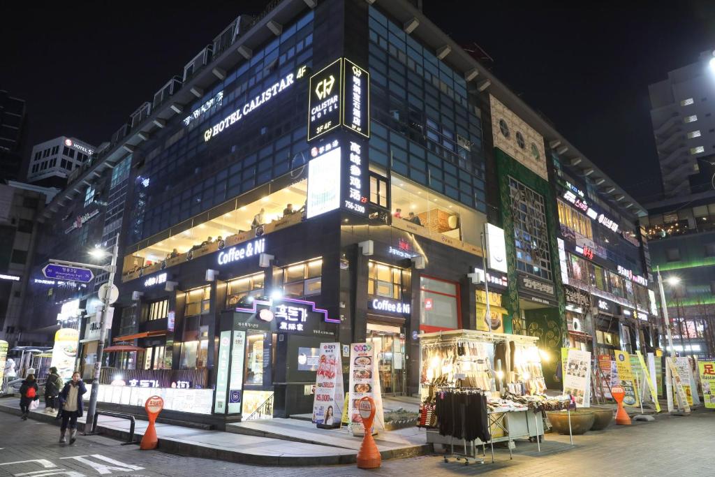 a large building with a lot of windows at night at Calistar Hotel in Seoul