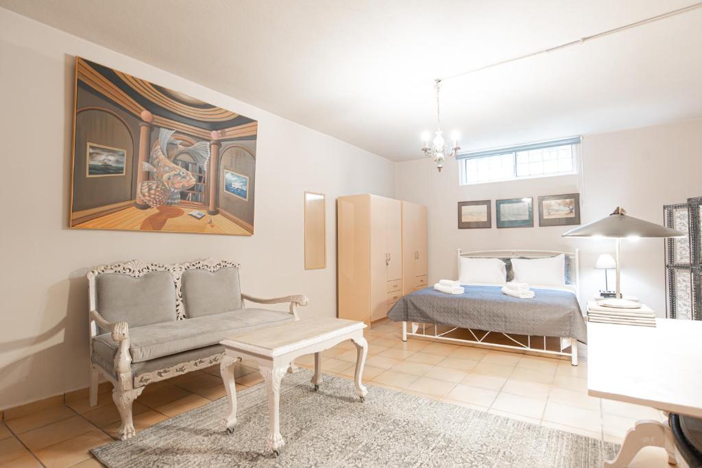 a bedroom with a bed and a couch and a table at The Country ArtHS Retreat in Athens