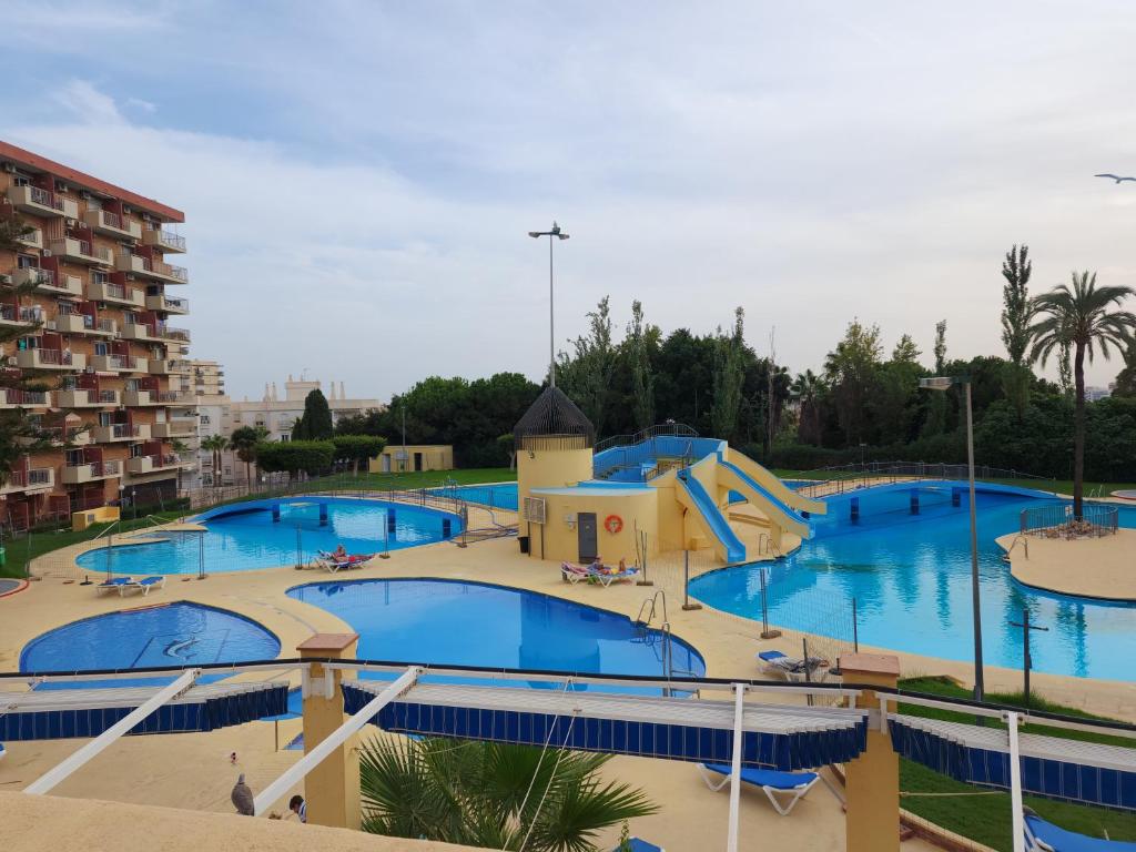una grande piscina con scivolo in un parco acquatico di Premium Studio Minerva 103 con Piscina y Parque Acuático a Benalmádena