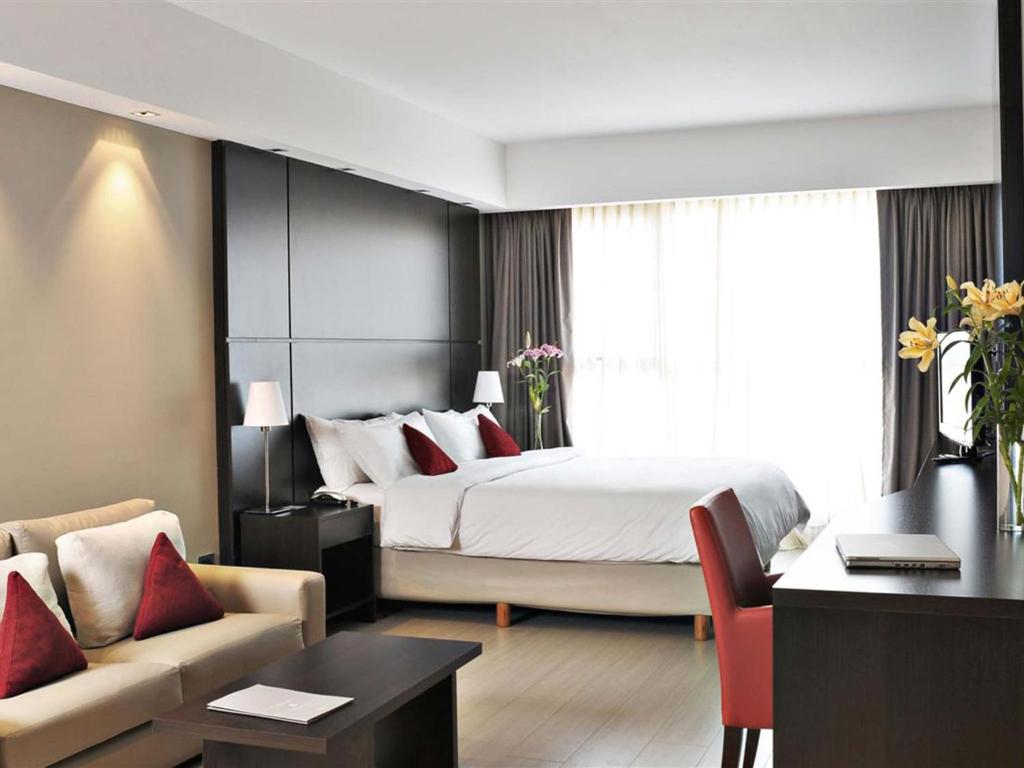 una camera d'albergo con un grande letto e una scrivania di HTL City Baires a Buenos Aires