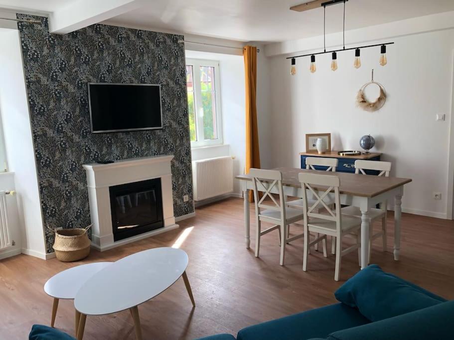 uma sala de estar com uma mesa e uma lareira em Le Carrousel - Appartement cosy centre Obernai em Obernai