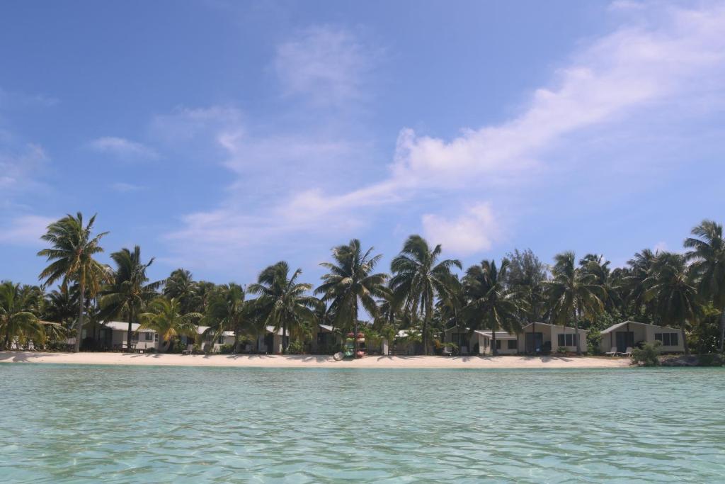 vistas a una playa con palmeras y casas en Ranginuis Retreat, en Arutanga