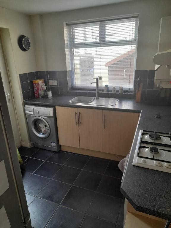 a kitchen with a sink and a washing machine at Alwyn House in Liverpool