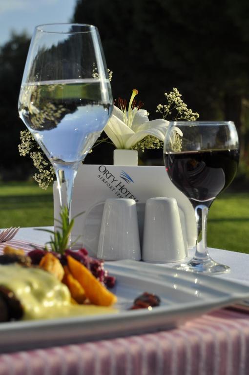 two glasses of wine and a plate of food at Orty Airport Hotel in Izmir