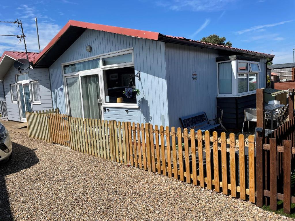 a small house with a fence in front of it at Pebbles 144 South Shore 2 bed chalet 2 dog friendly, sleeps 4 in Bridlington