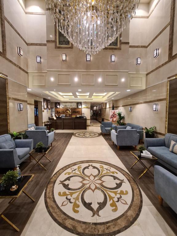 a lobby with couches and a chandelier at Rasis Furnished Apartments in Jeddah