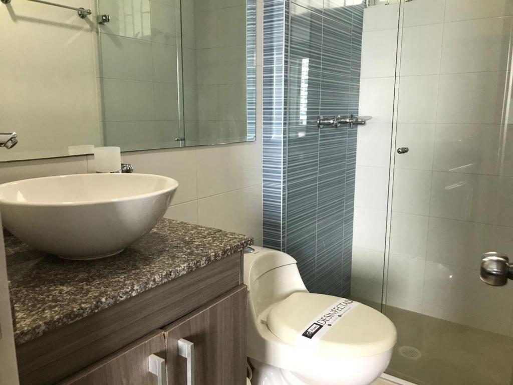 a bathroom with a sink and a toilet and a glass shower at Apartamento Duplex con vista al mar in Gaira