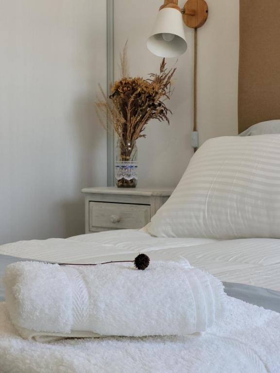 Una cama blanca con toallas y una mesa. en DEPARTAMENTO LA GAVIOTA en Salta