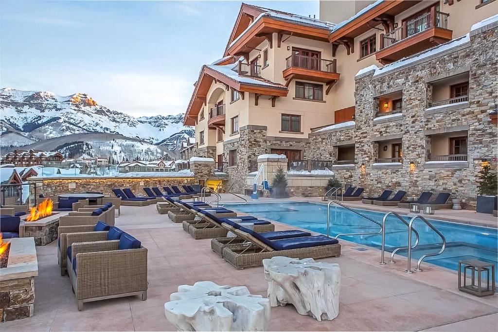 un complexe avec une piscine et des montagnes en arrière-plan dans l'établissement Forbes 5 Star Luxury Hotel - 1 Br Residence in Mountain Village Colorado, à Telluride