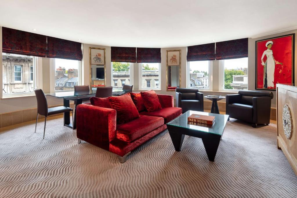 a living room with a red couch and a table at Radisson Blu Hotel, London Bloomsbury in London