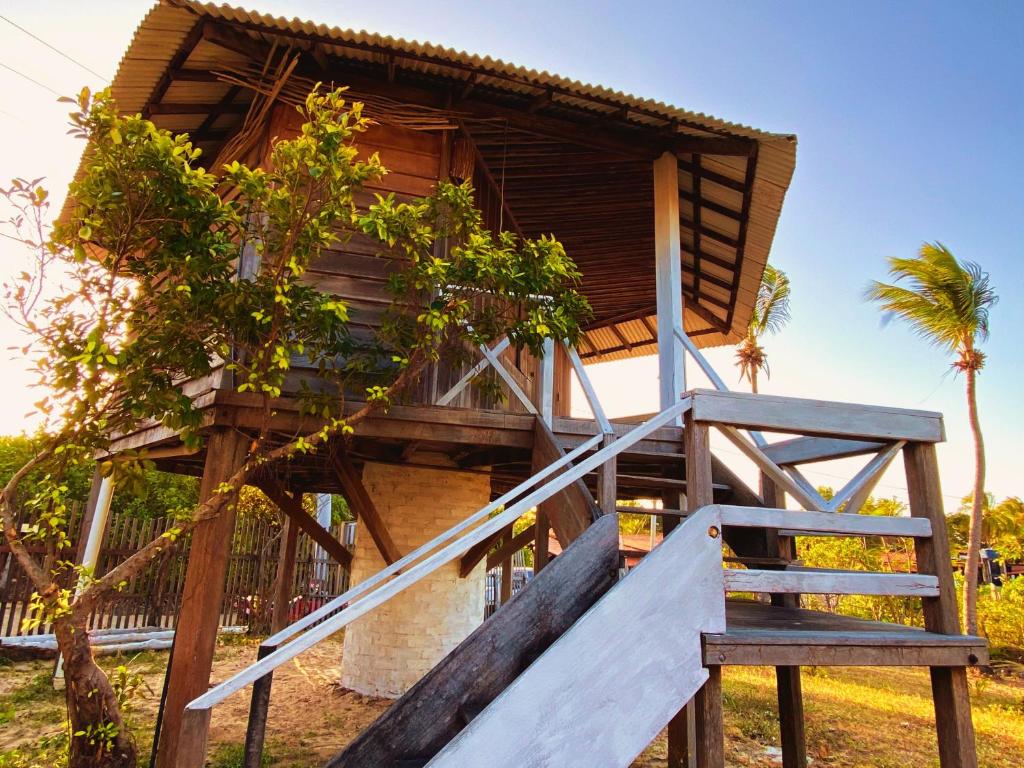 a tree house with a staircase leading up to it at Chalés da VoVó in Atins