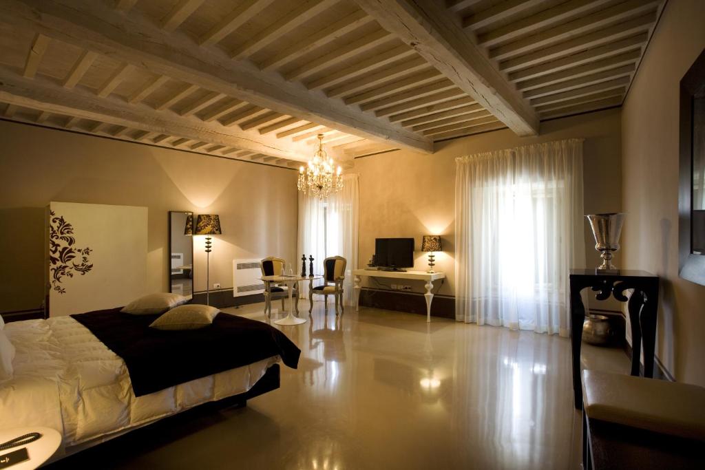 a bedroom with a bed and a living room at Palazzo Bontadosi Hotel & Spa in Montefalco