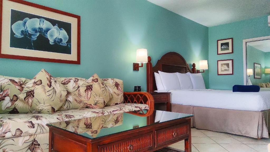 Habitación de hotel con sofá y cama en Trade Winds Hotel, en Dickenson Bay