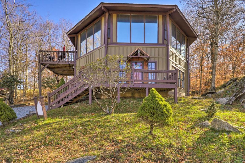 una casa en el árbol con una gran terraza y una escalera en Beech Mountain Resort Home with Deck and Hot Tub!, en Beech Mountain