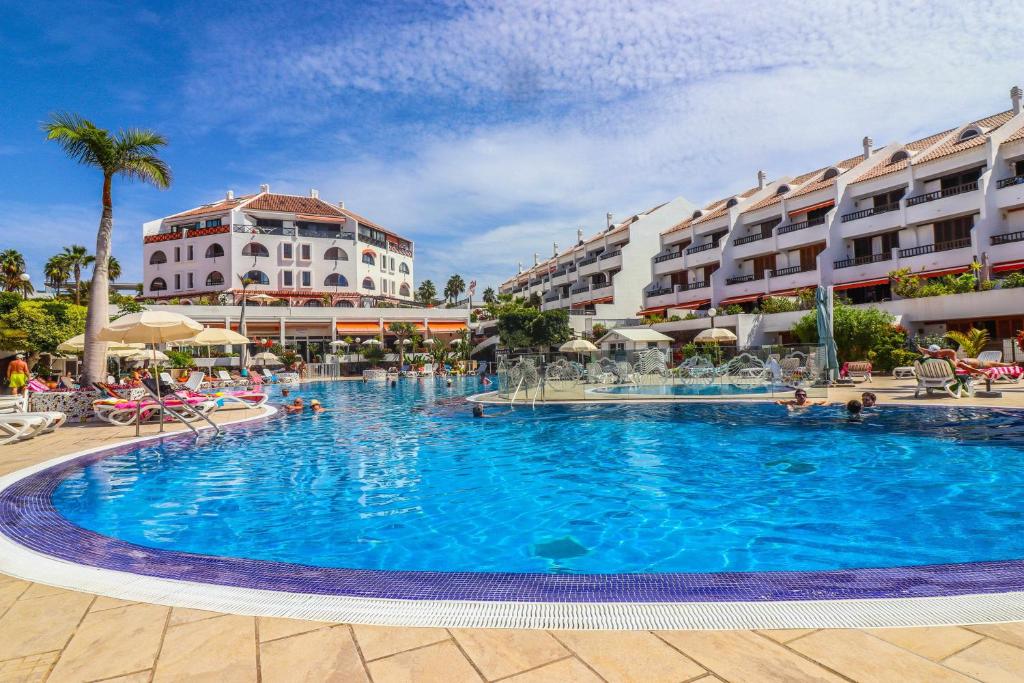 a large swimming pool in front of some buildings at Rentaliday Garden Beach in Playa de las Americas