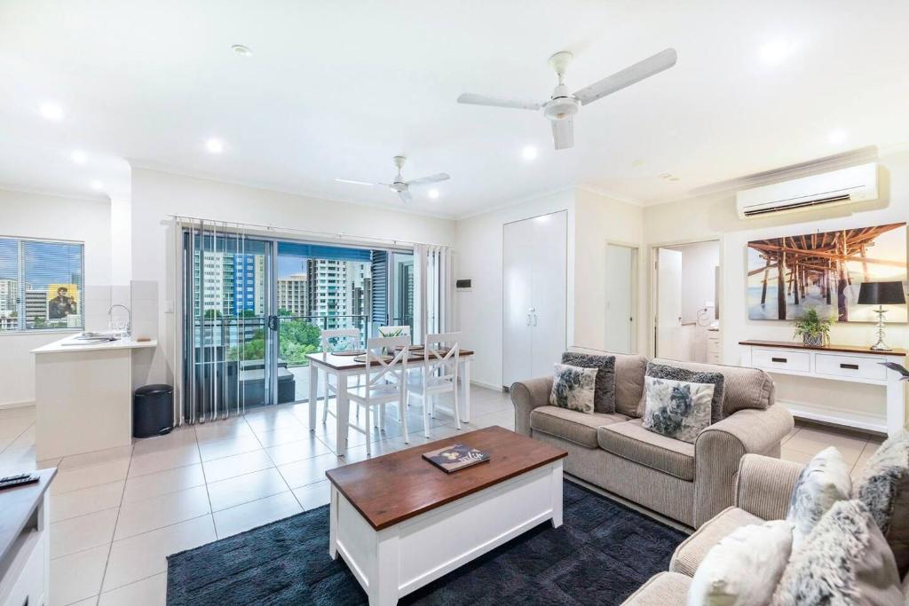 a living room with a couch and a table at Your Keys to Larrakeyah Coastal Comfort with Pool in Larrakeyah
