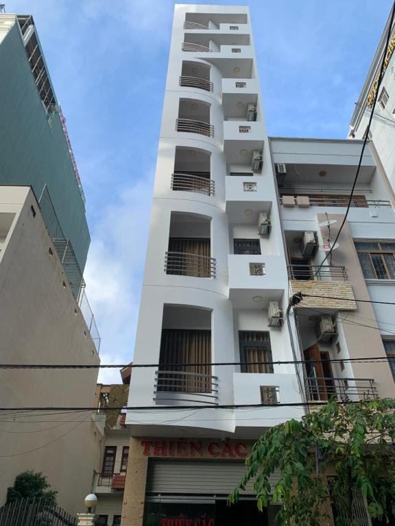 un edificio alto y blanco con balcones. en Thiên Các Hotel, en Quy Nhon