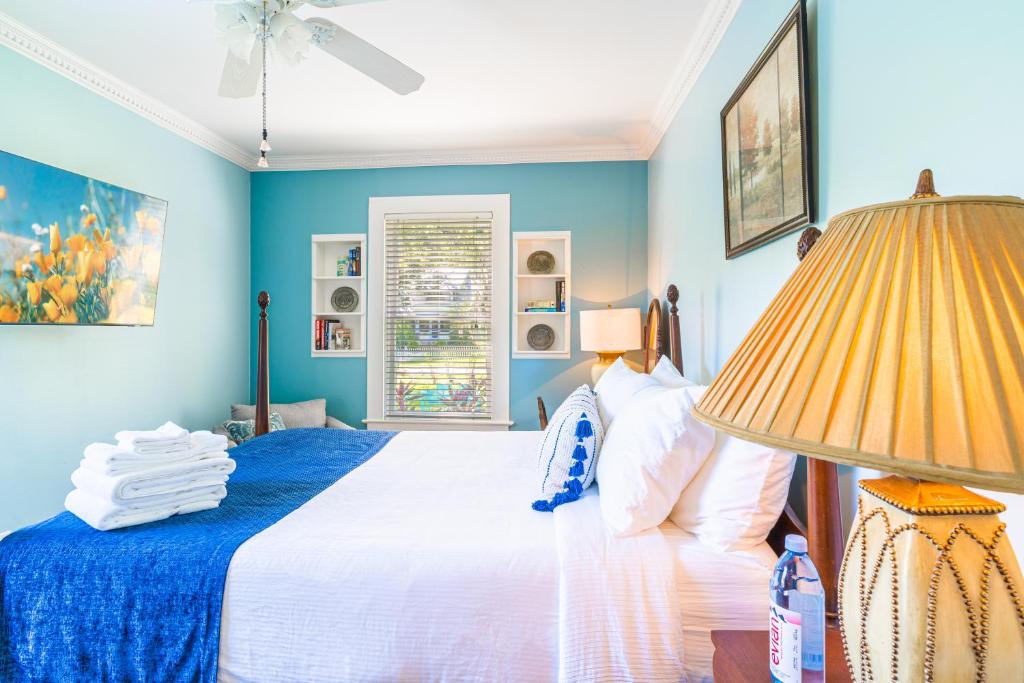 a bedroom with a bed with blue walls and a lamp at The Estate at Mt Dora in Mount Dora