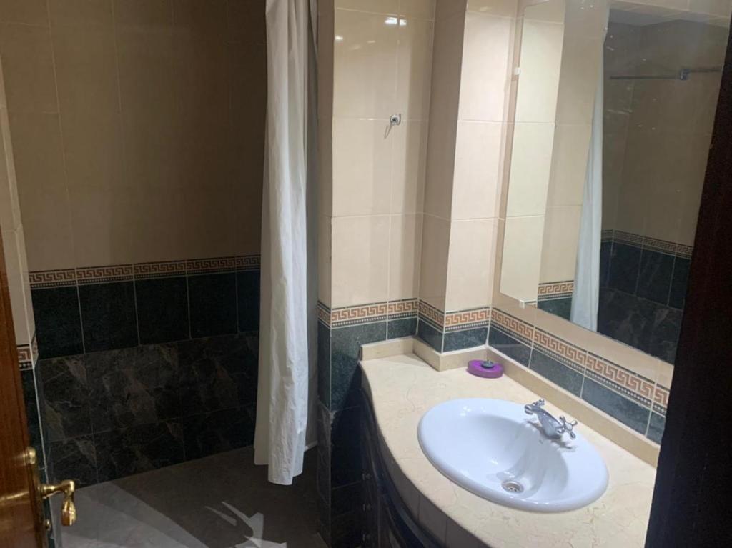 La salle de bains est pourvue d'un lavabo et d'une douche. dans l'établissement Marina Agadir appartement, à Agadir