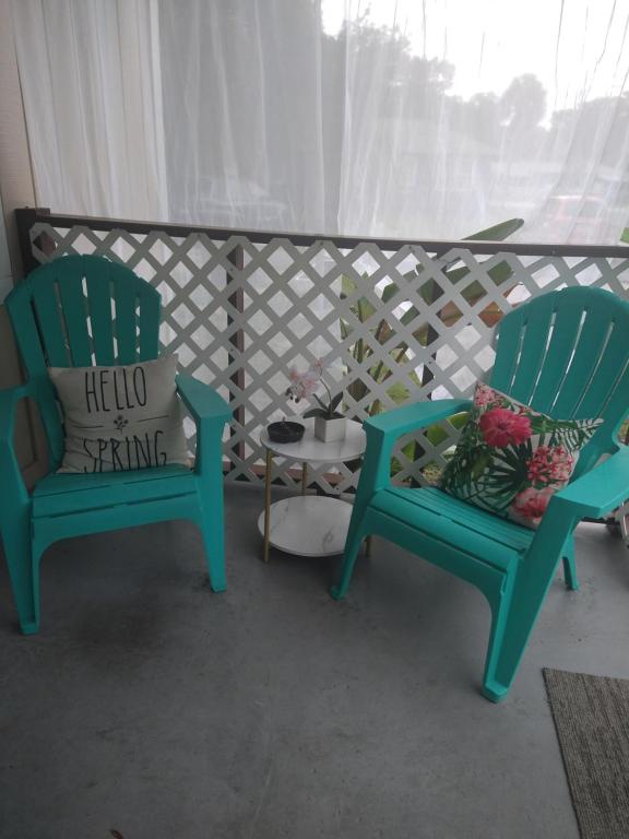 twee groene stoelen en een tafel op een balkon bij Life is good in St Petersburg