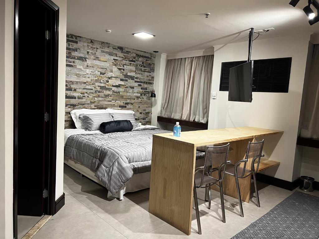 a bedroom with a bed and a table with chairs at Flat - Al Santos - Prox Av Paulista in Sao Paulo