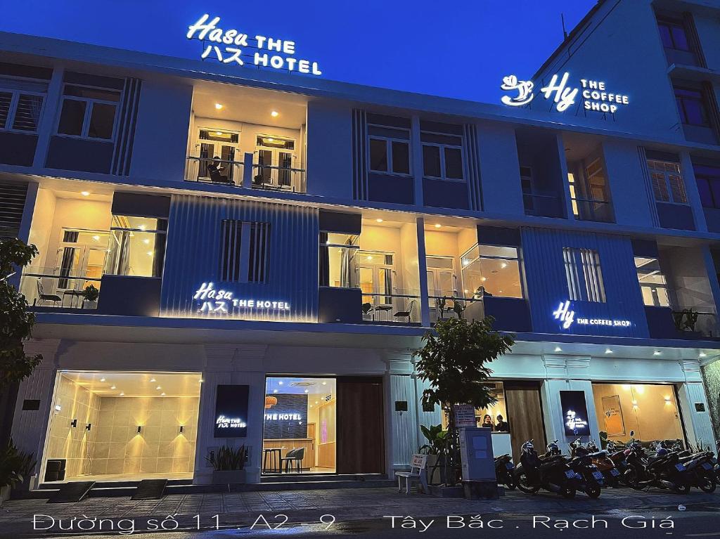 un gran edificio azul con ventanas por la noche en Hasu The Hotel, en Rạch Giá