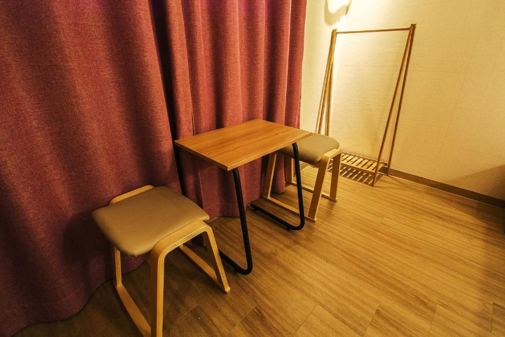 uma mesa e duas cadeiras em frente a uma cortina em Hotel Violet em Goyang