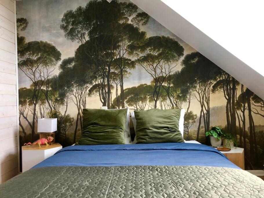 a bedroom with a bed with a mural of trees at Le petit St-Jean in Bagnères-de-Bigorre