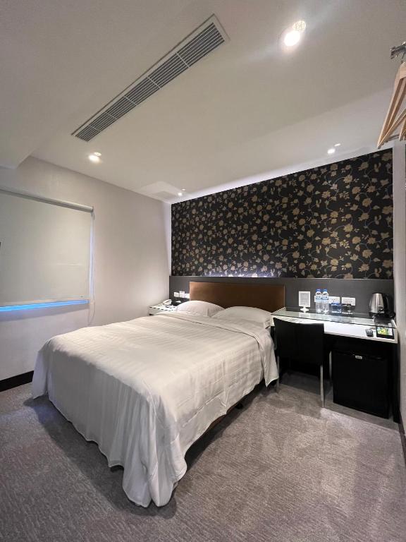 a bedroom with a large bed and a desk at Hotel Puri in Taipei