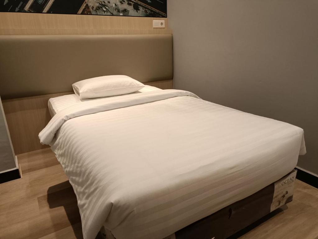 A bed or beds in a room at Odua Golden Mansyur Medan