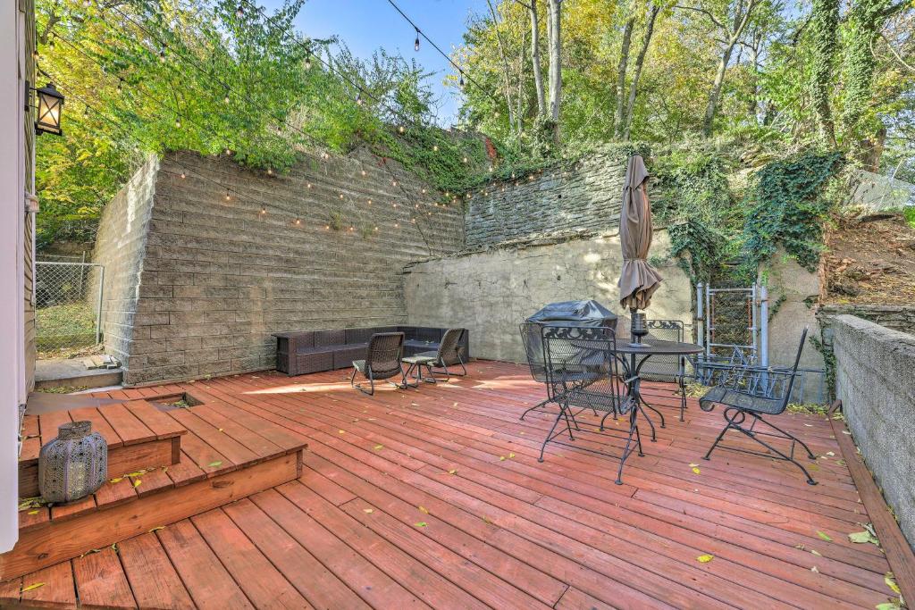 una terrazza in legno con tavolo, sedie e ombrellone di Beautiful Historic Cincy Home Walk to OTR! a Cincinnati