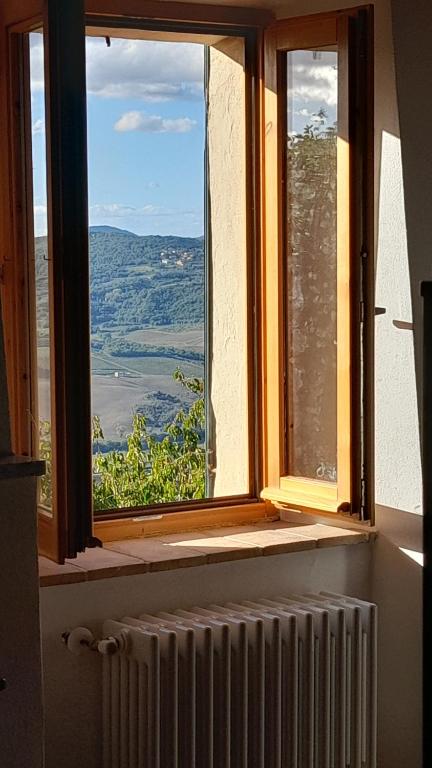 una finestra aperta con vista sulle montagne di Appartamento Athena a Montepulciano