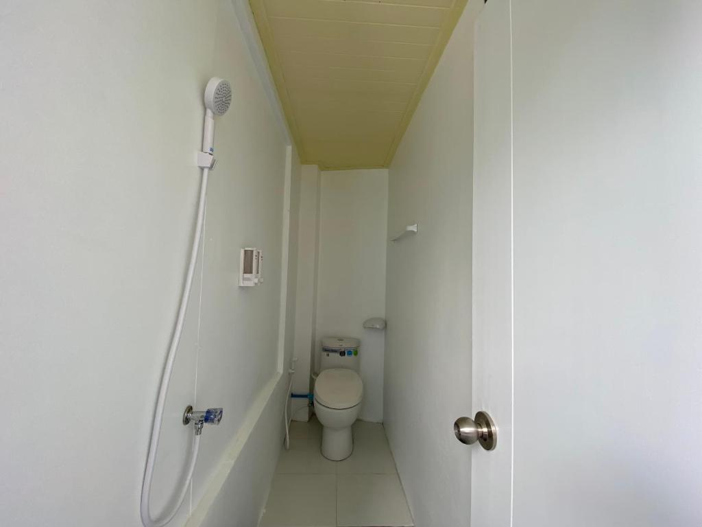 um pequeno banheiro com vaso sanitário e chuveiro em Blue Flow Hostel em Phi Phi Don