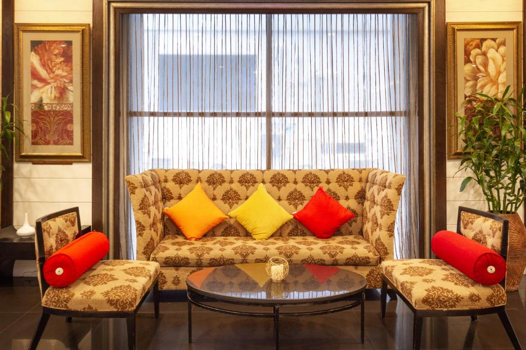 a living room with a couch with colorful pillows at FuramaXclusive Sukhumvit in Bangkok