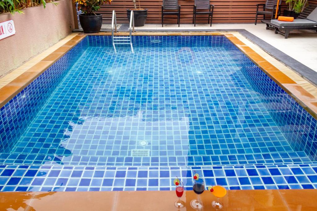 a swimming pool with blue tiles on the floor at FuramaXclusive Sukhumvit in Bangkok