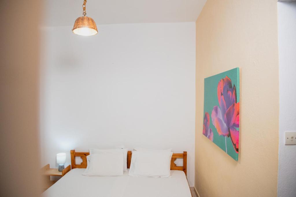 a bedroom with two beds and a painting on the wall at Arriba Apartments in Afissos