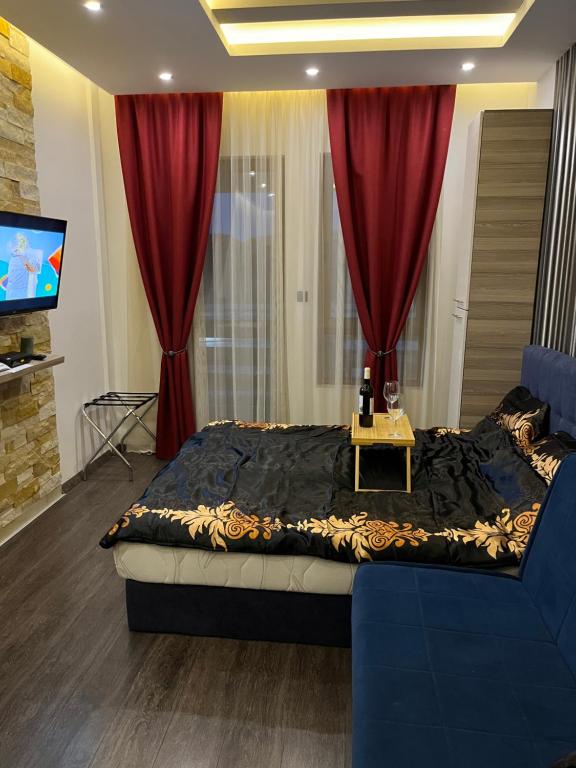um quarto com uma cama com cortinas vermelhas e uma televisão em Ski & Spa K2 Milmari resort em Kopaonik