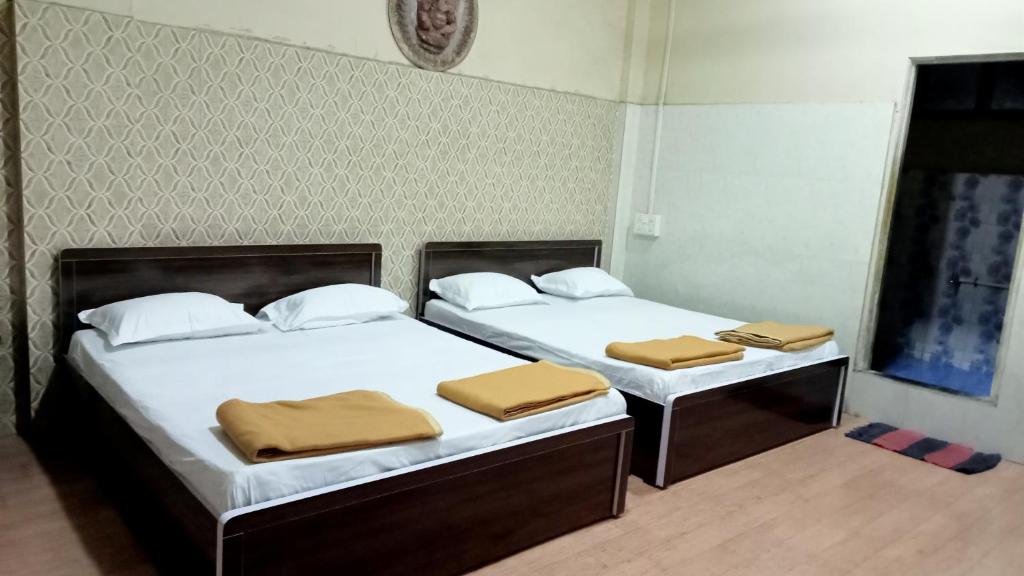 two beds in a room with two beds sidx sidx sidx at Shree Yatri Niwas in Kolhapur
